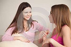 Two young girlfriends having personal conversation.