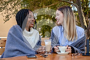 Two young girlfriends talking and enjoying in coffee together.