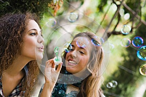 Two young girls blowing bubbles