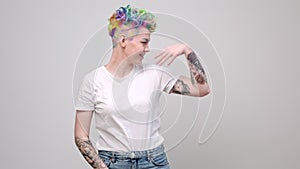 Two young girls with bright colored dyed hair and short haircuts. Hairdresser colorist and model pose against a white