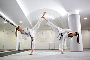 Two young girls demonstrating taekwondo