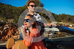 Two young girls having fun in the cabriolet outdoors