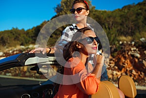 Two young girls having fun in the cabriolet outdoors