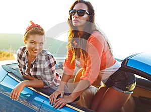 Two young girls having fun in the cabriolet outdoors