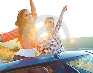 Two young girls having fun in the cabriolet outdoors