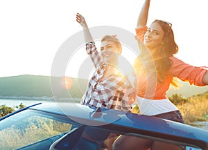 Two young girls having fun in the cabriolet outdoors