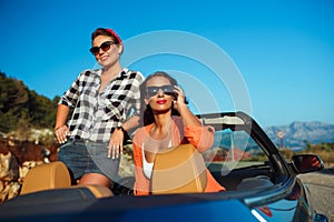 Two young girls having fun in the cabriolet outdoors