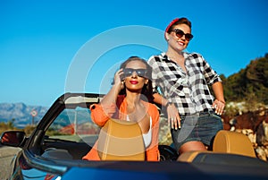 Two young girls having fun in the cabriolet outdoors