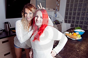 Two young girls in the kitchen talking and eating