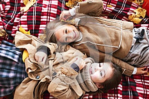 Two Young Girls Laughing In The Leaves in autumn park