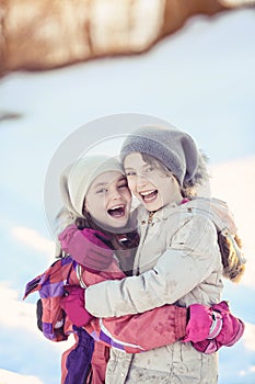 Two young girls laughing on sunny winter day