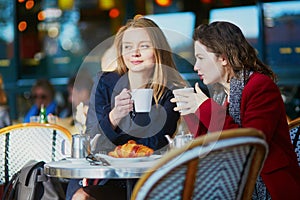 Two young girls in Parisian outdoor cafe