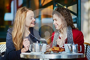 Two young girls in Parisian outdoor cafe