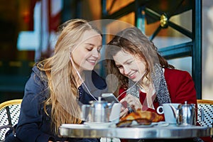 Two young girls in Parisian outdoor cafe