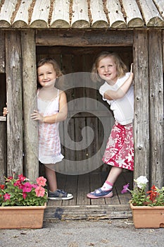 Two Young Girls Playing in Wooden House