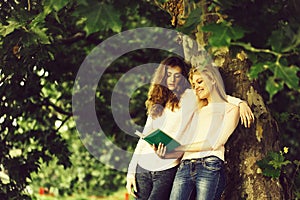 Two young girls read book