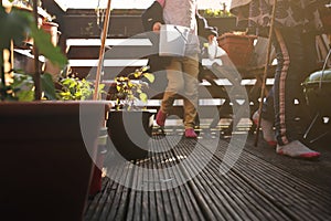 two young girls taking care of plants on a wooden balcony