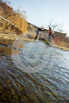 Two young girls try to cross the river