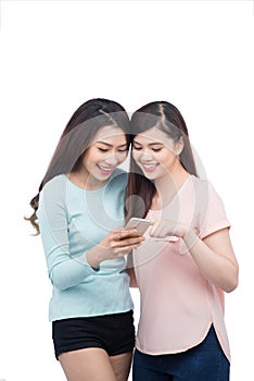 Two young girls using smart phone. Smiling young female friends