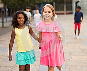 Two young girls walking hand in hand