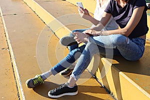 Two young girls watching mobile phones