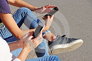 Two young girls watching mobile phones