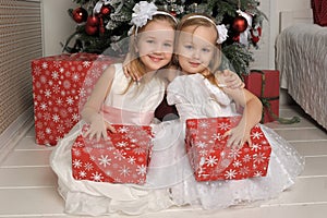 Two young girls in white dresses with gifts