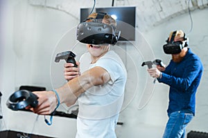 Two young guys are playing in virtual reality glasses