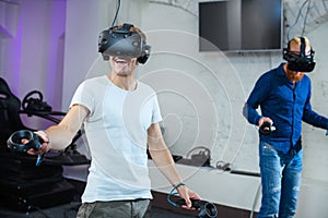 Two young guys are playing in virtual reality glasses