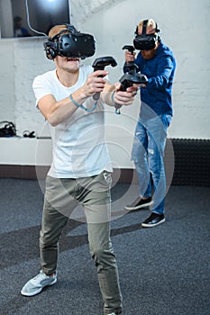 Two young guys are playing in virtual reality glasses