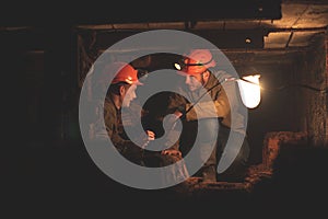 Two young guys in a working uniform and protective helmets