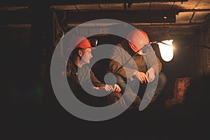 Two young guys in a working uniform and protective helmets