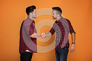 Two young handsome men shaking hands.