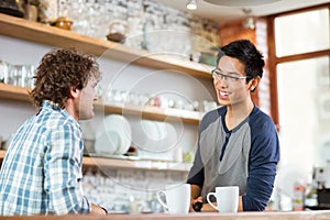 Two young handsome men talking in cafe