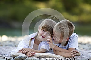 Two young happy cute blond smiling children, boy and girl, broth