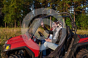 two young happy excited men enjoying beautiful sunny day while driving a off road buggy car