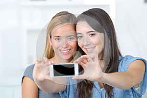 Two young happy friends making selfie