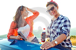 Two young happy girls having fun in the cabriolet outdoors