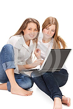 Two young happy student girl work on laptop