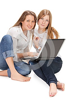 Two young happy student girl work on laptop
