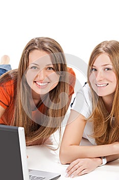 Two young happy student girl work on laptop