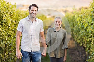 Two young happy vintners holding hands photo