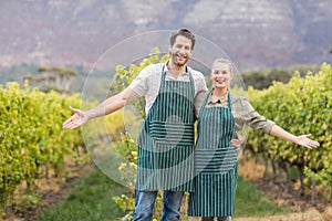 Two young happy vintners showing their fields photo
