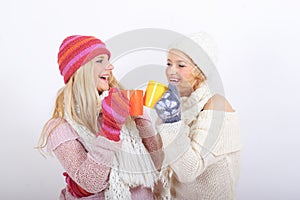 Two young happy winter woman with cup of tea