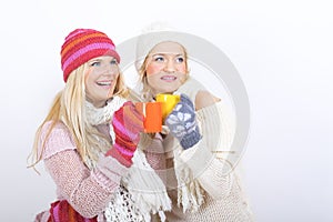 Two young happy winter woman with cup of tea