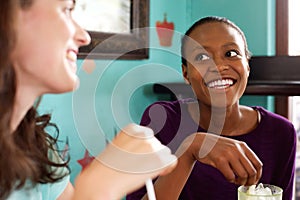 Two young ladies chatting in a cafe photo