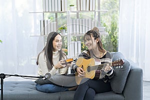 Two young ladies playing kalimba and guitar in the living room