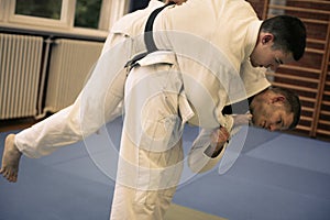 Two young males practicing judo together.