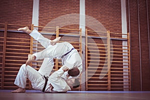 Two young males practicing judo together.