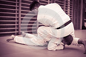 Two young males practicing judo together.